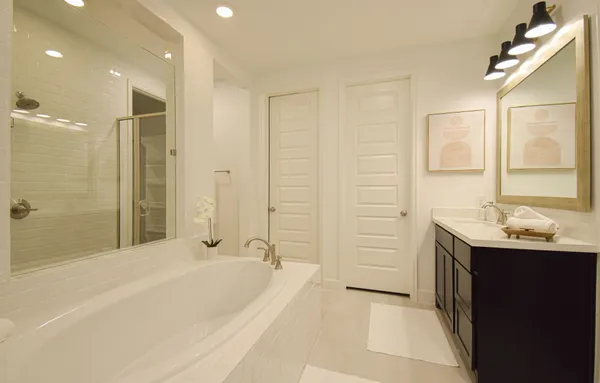 a spacious bathroom with a bathtub sink and mirror
