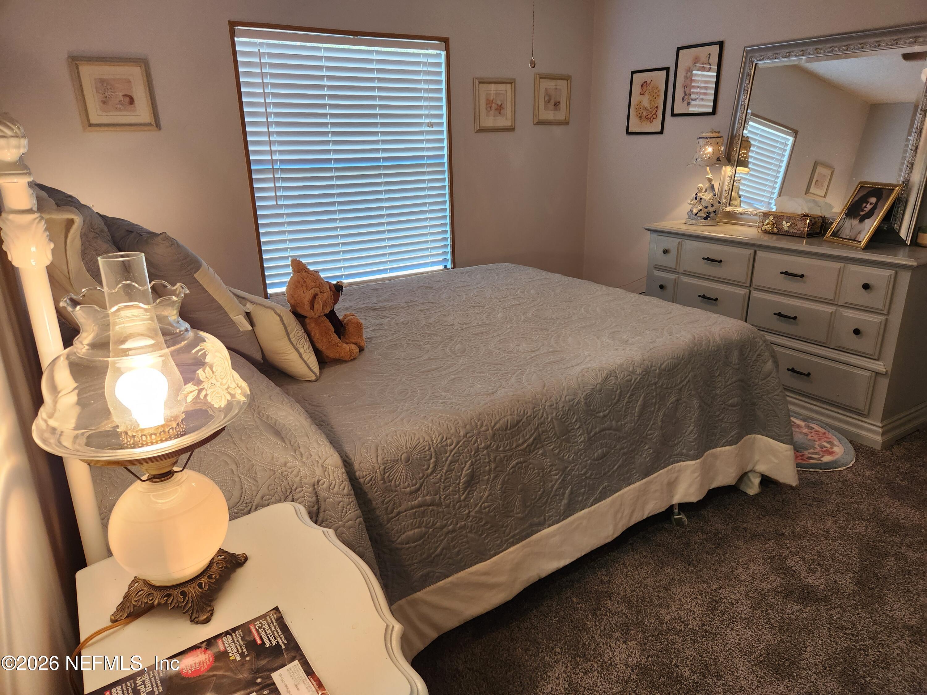 6863 Deer Springs Road Keystone Heights, FL 32656 - Photo 19 of 20 a bedroom with a bed and dresser with mirror