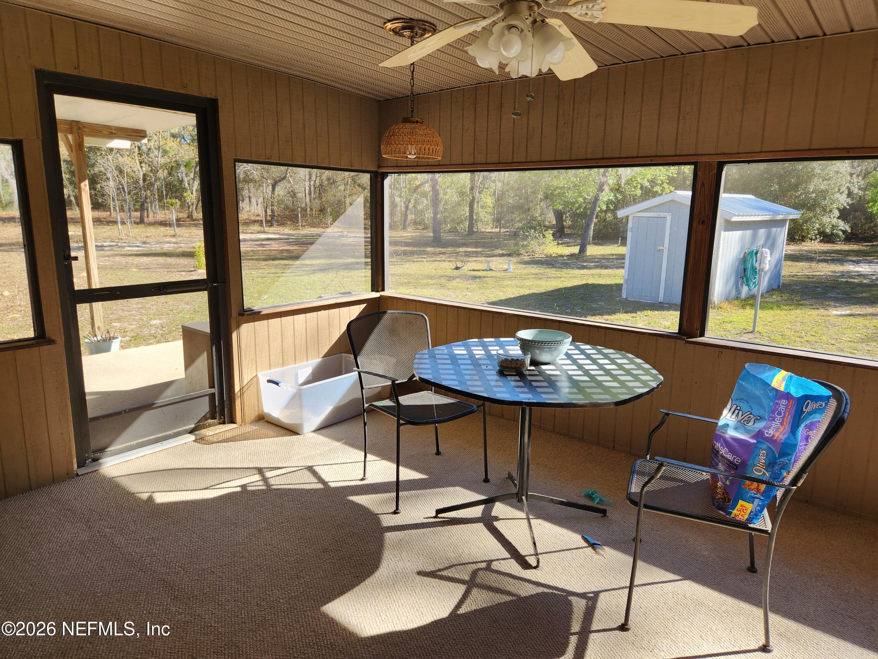 6863 Deer Springs Road Keystone Heights, FL 32656 - Photo 9 of 20 a view of a dining room with furniture wooden floor and a floor to ceiling window