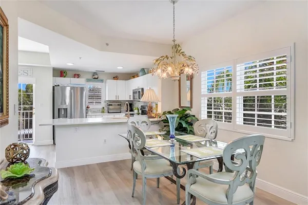 a dining room with furniture a chandelier and wooden floor