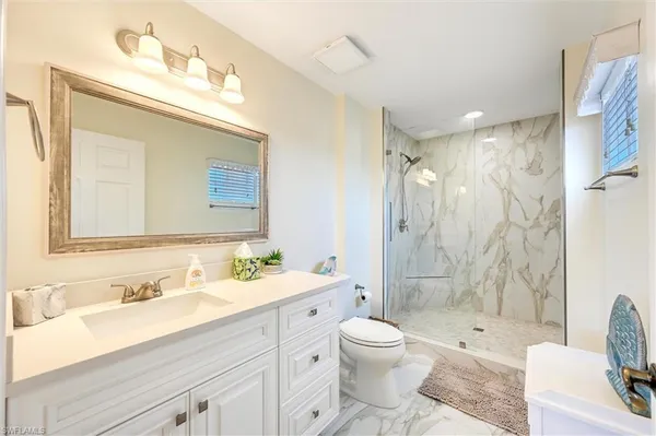 a white toilet sitting next to a bathroom sink