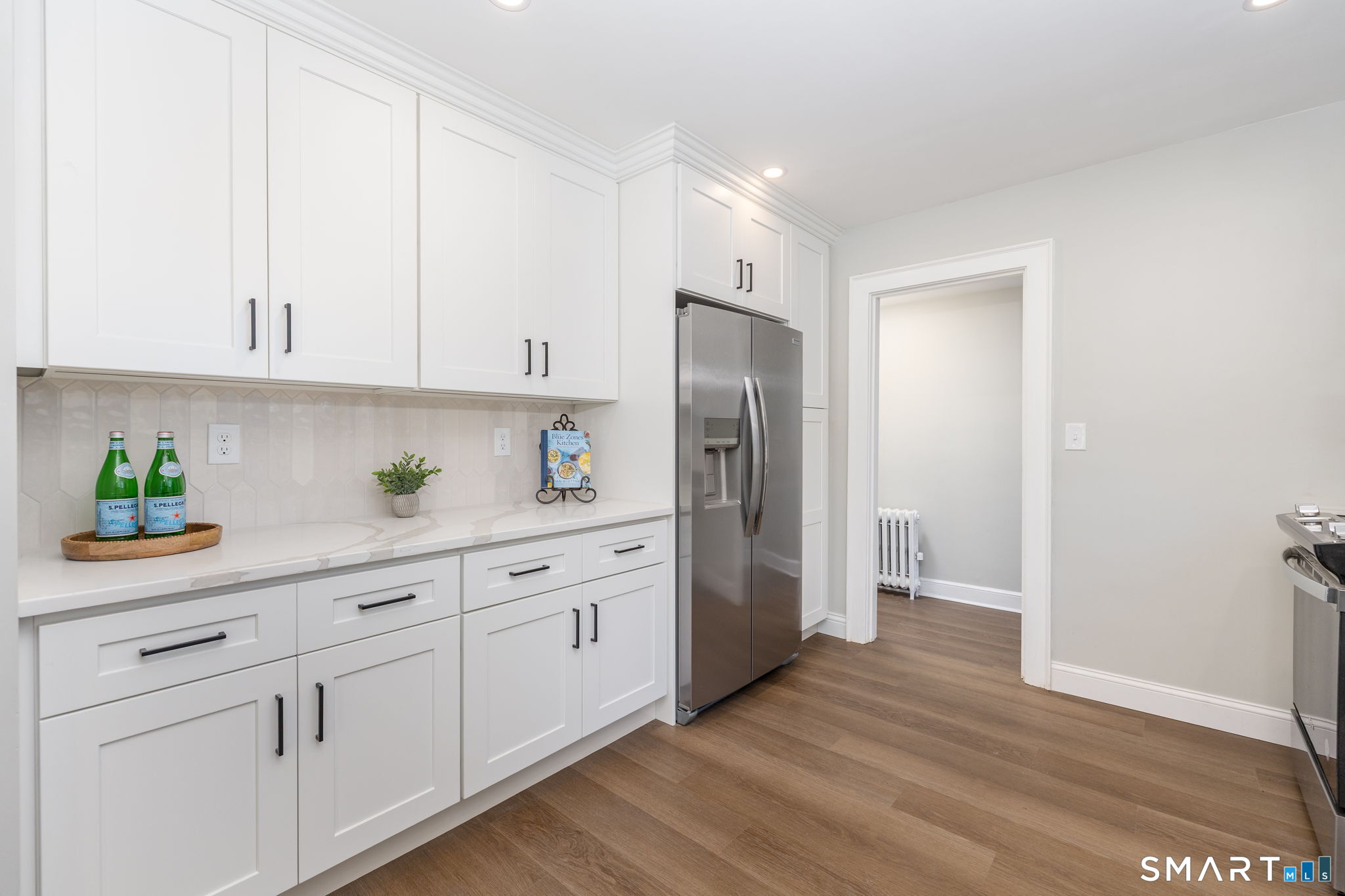 51 Hepburn Road Hamden, CT 06517 - Photo 4 of 40 a kitchen with stainless steel appliances white cabinets and wooden floors