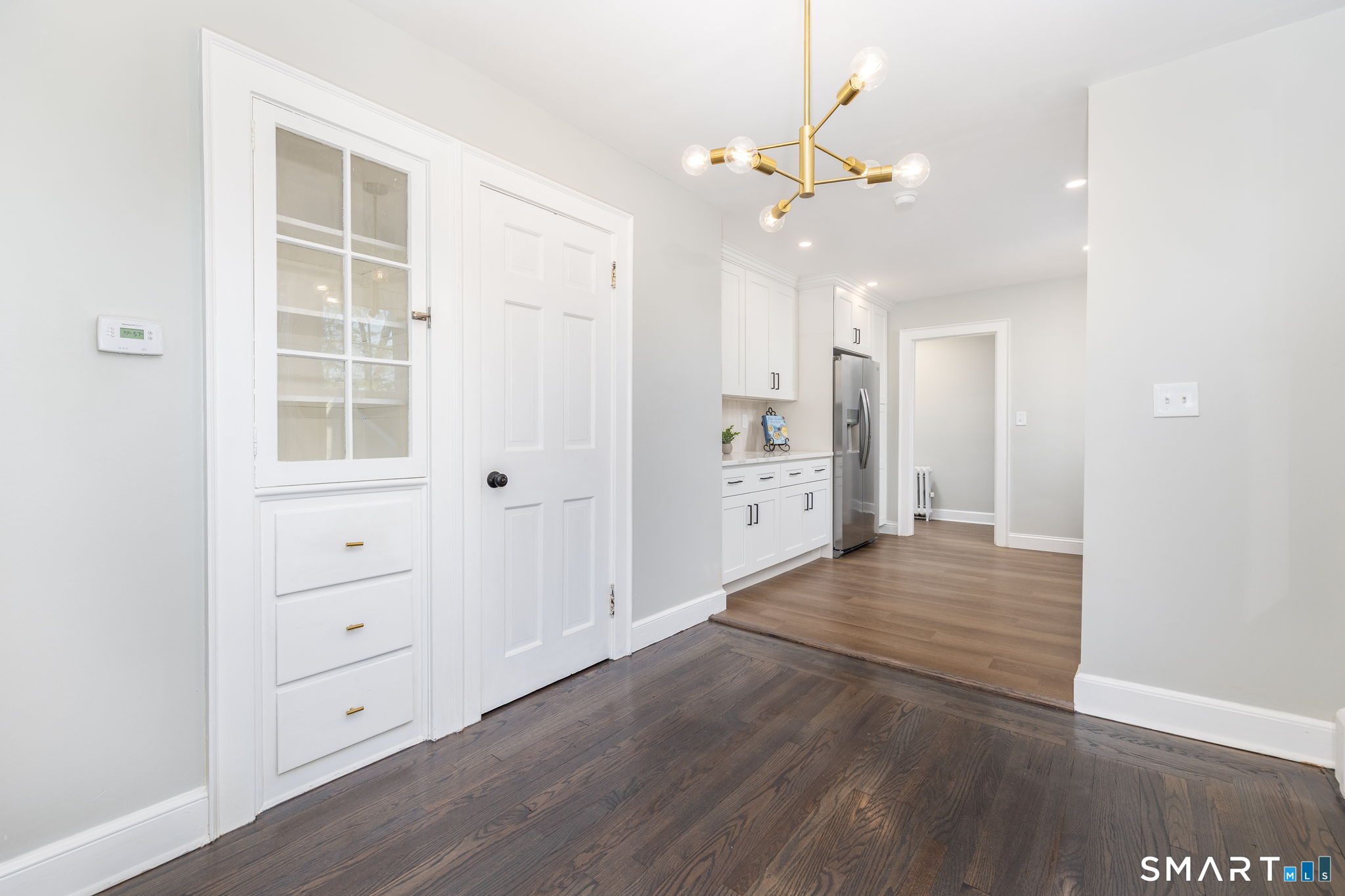 51 Hepburn Road Hamden, CT 06517 - Photo 5 of 40 an empty room with wooden floor cabinet and windows