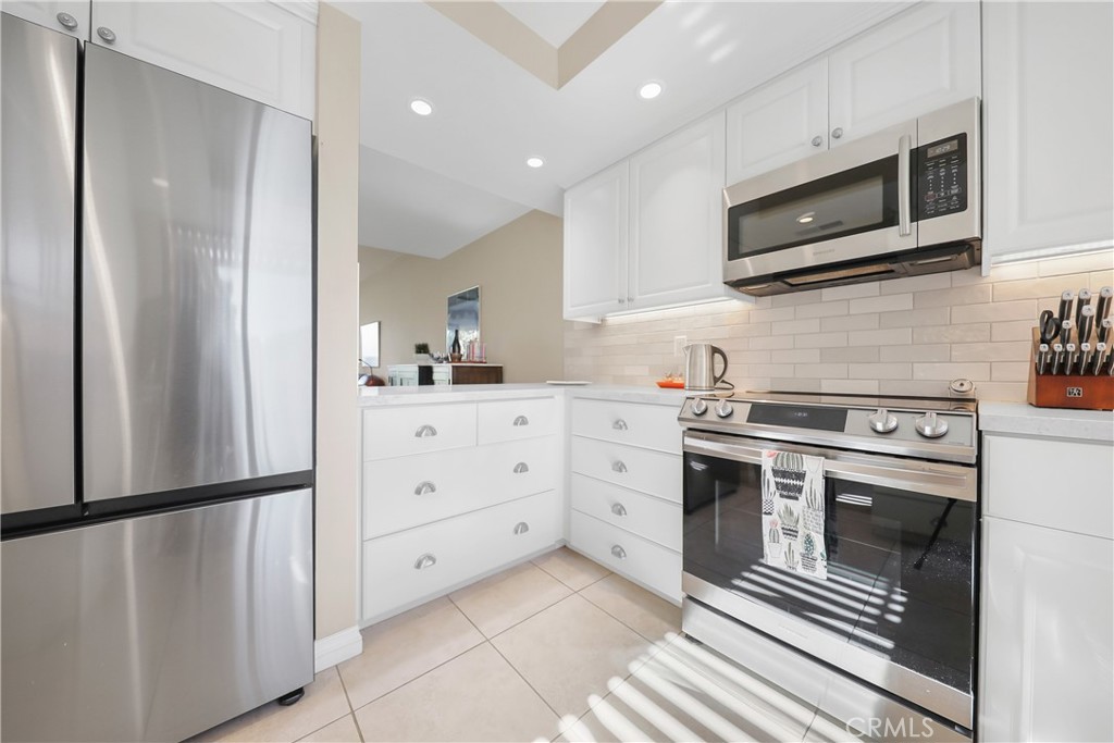 48 Palma Drive Rancho Mirage, CA 92270 - Photo 11 of 32 a kitchen with stainless steel appliances a stove microwave and refrigerator