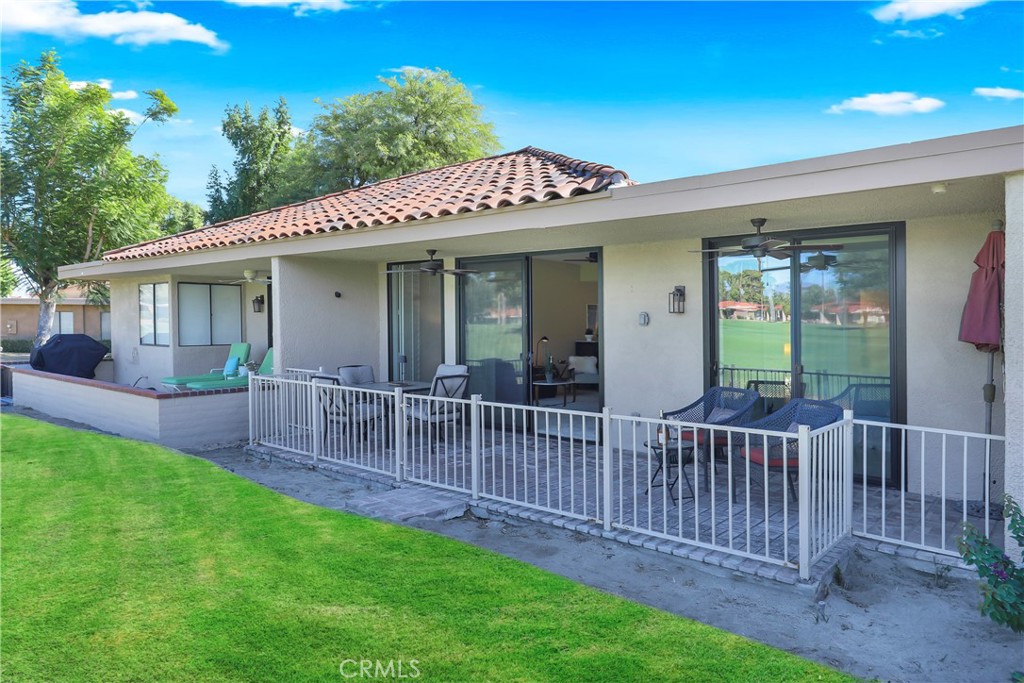 48 Palma Drive Rancho Mirage, CA 92270 - Photo 23 of 32 a view of a house with a small yard and a wooden deck