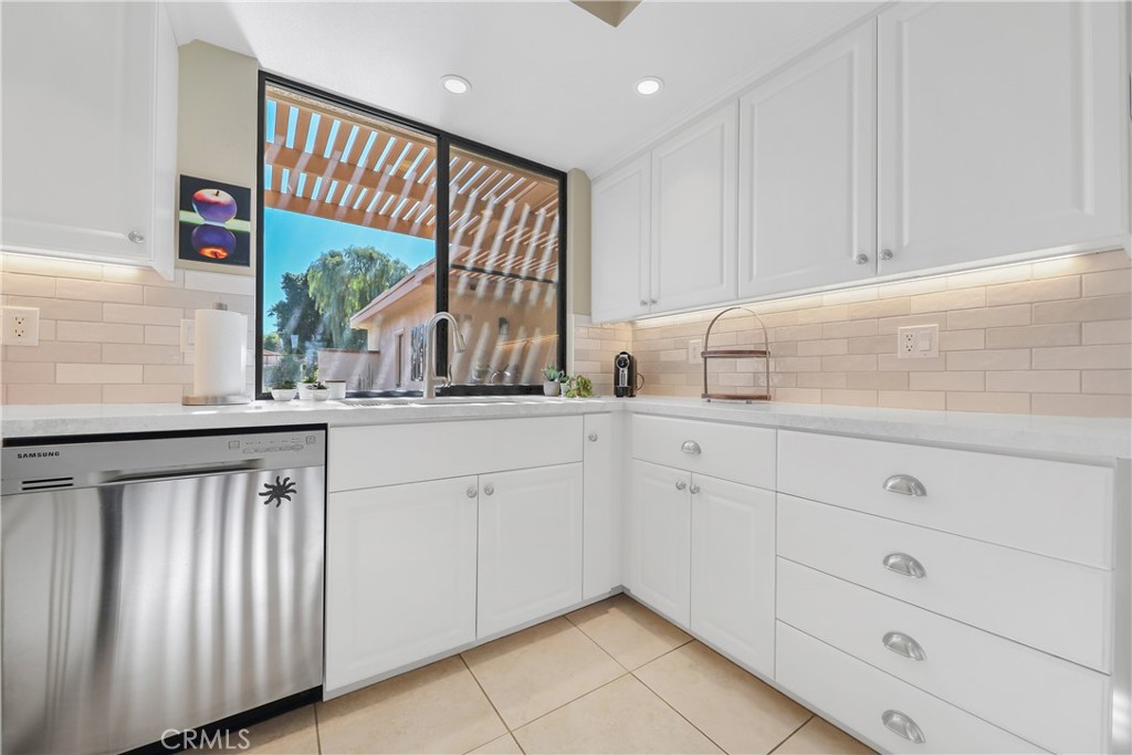 48 Palma Drive Rancho Mirage, CA 92270 - Photo 10 of 32 a kitchen with white cabinets and a window