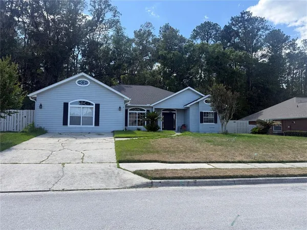 a front view of a house with a garden and trees