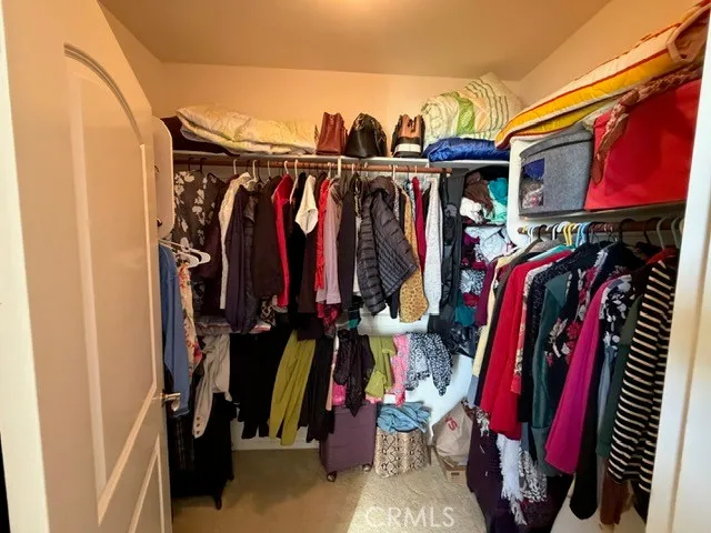 a view of walk in closet with clothes