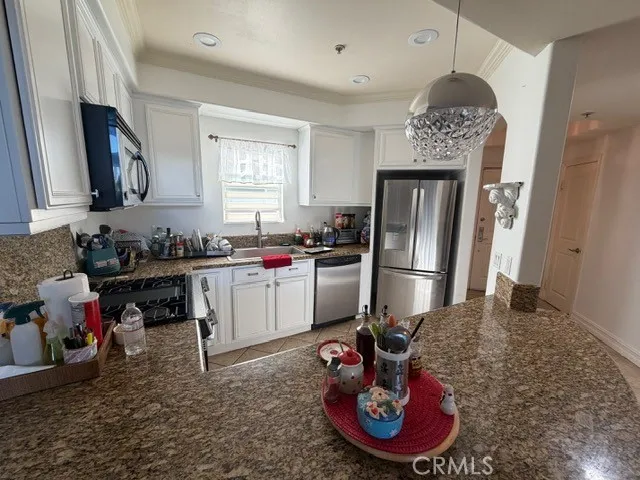 a kitchen with a refrigerator a stove a sink and a cabinets
