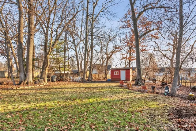 a front view of a house with a yard covered with snow and trees