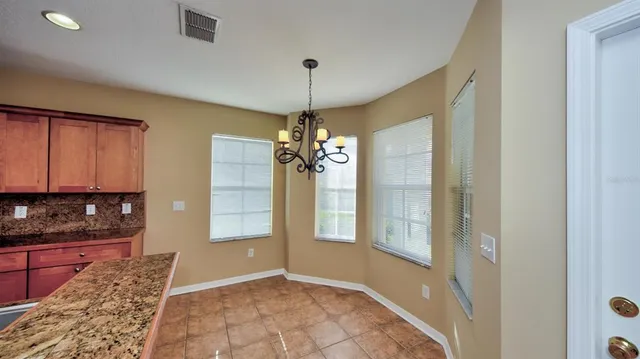 a view of a hallway with windows and chandelier
