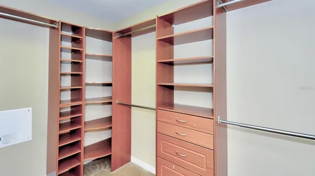 a view of walk in closet with empty racks