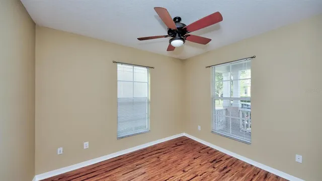 a view of an empty room with a window and wooden floor