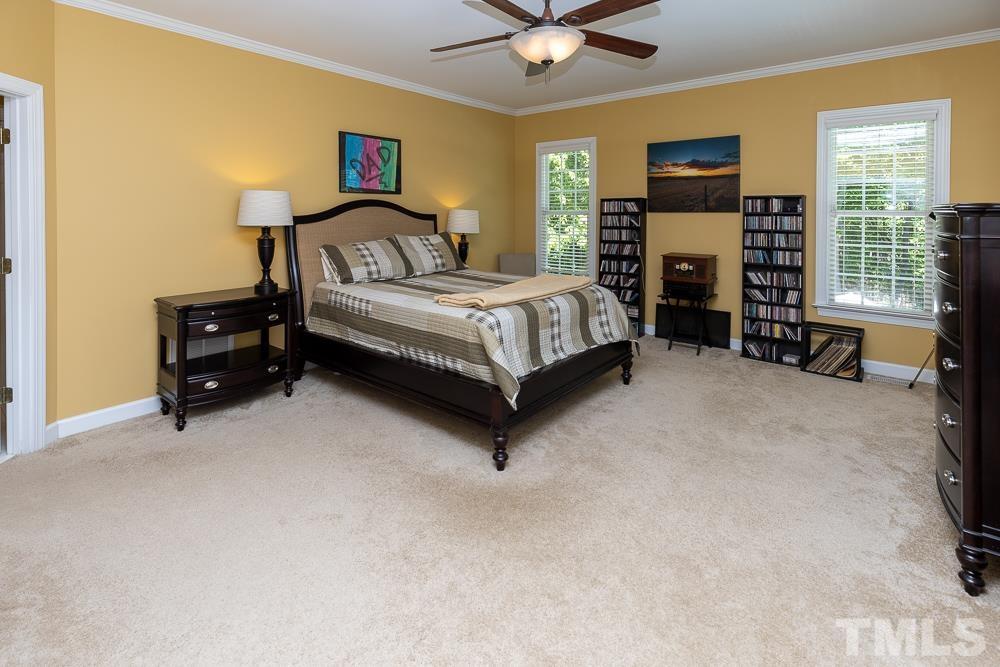 12625 Amoretto Way Raleigh, NC 27613 - Photo 17 of 42 a bedroom with a bed flat screen tv and a fireplace