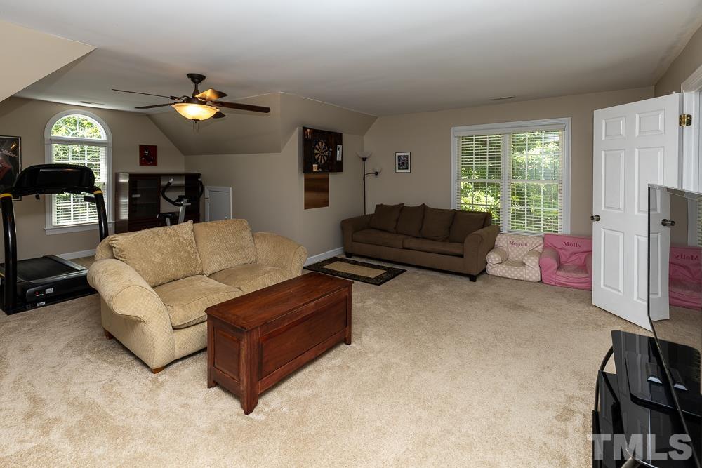 12625 Amoretto Way Raleigh, NC 27613 - Photo 22 of 42 a living room with furniture and a flat screen tv