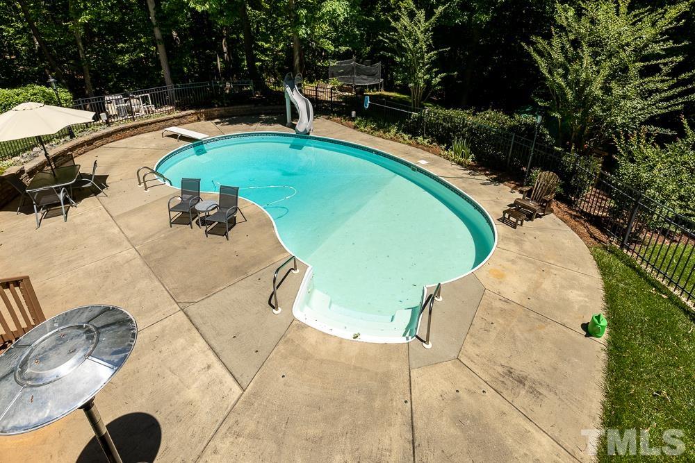 12625 Amoretto Way Raleigh, NC 27613 - Photo 33 of 42 a view of a swimming pool with a yard and seating area