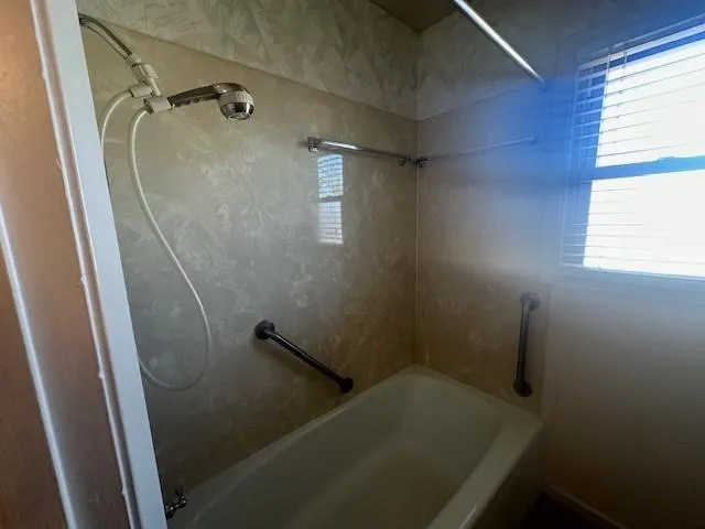 a bathroom with a tub and window