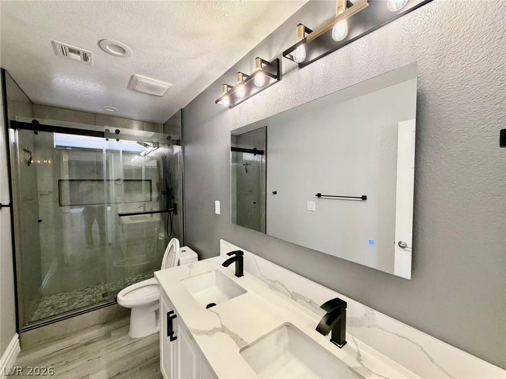 135 Tall Ruff Drive Las Vegas, NV 89148 - Photo 23 of 29 A well-appointed bathroom with a dual vanity, sleek fixtures, and a glass-enclosed shower.