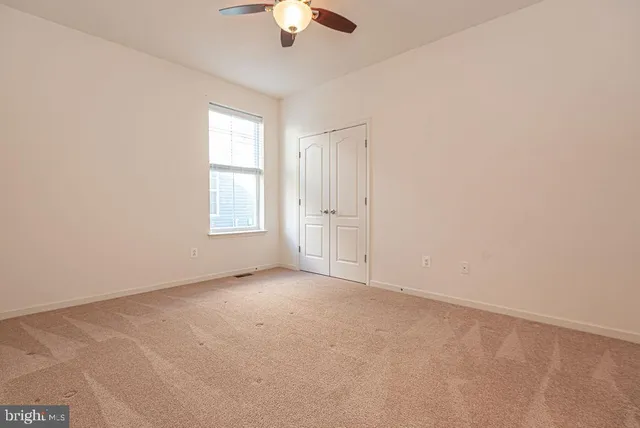 an empty room with a empty space and a ceiling fan