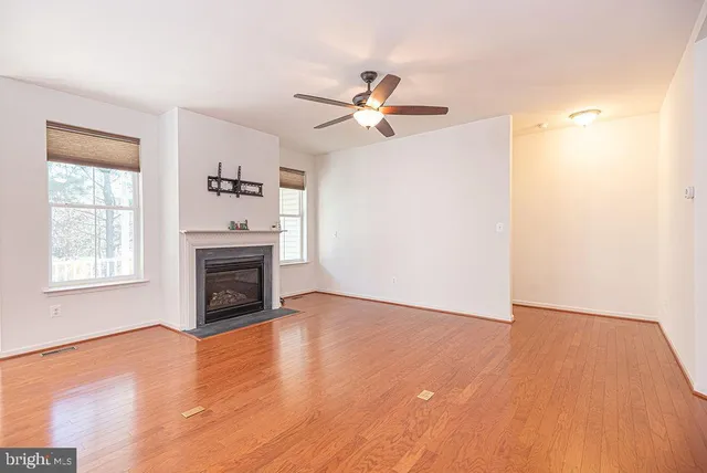 a view of empty room with a fireplace and wooden floor