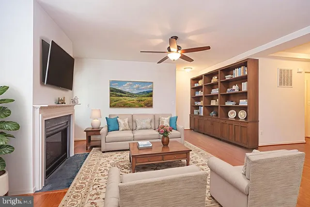 a living room with furniture a flat screen tv and a fireplace
