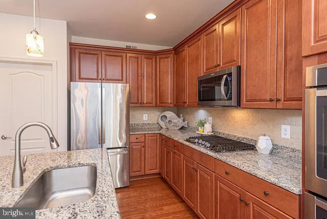 a kitchen with granite countertop a stove sink and cabinets