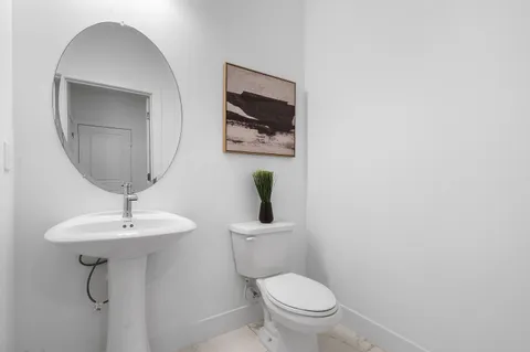 a bathroom with a toilet a sink and mirror