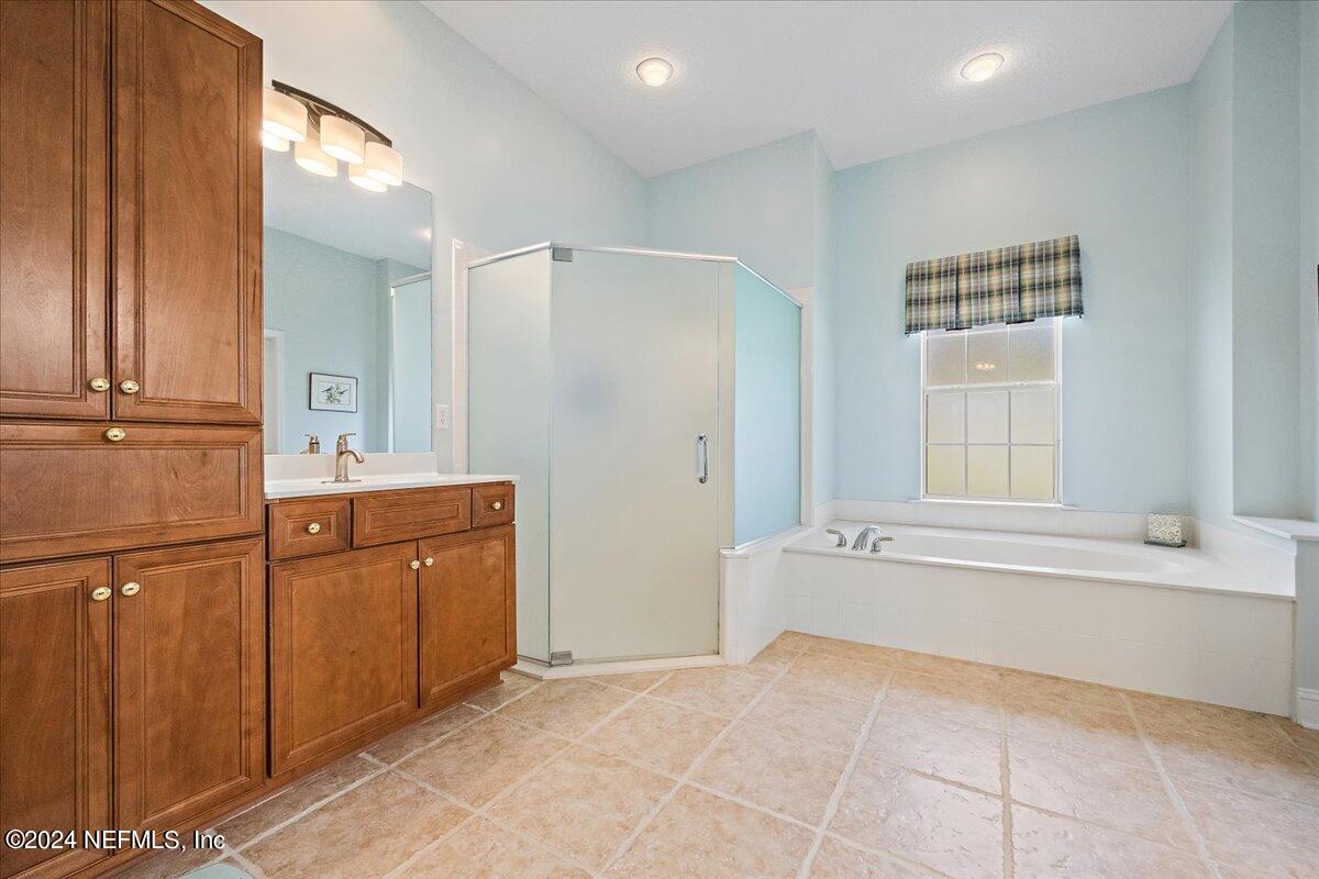 757 Eagle Point Drive St. Augustine, FL 32092 - Photo 16 of 44 a bathroom with a tub sink and mirror