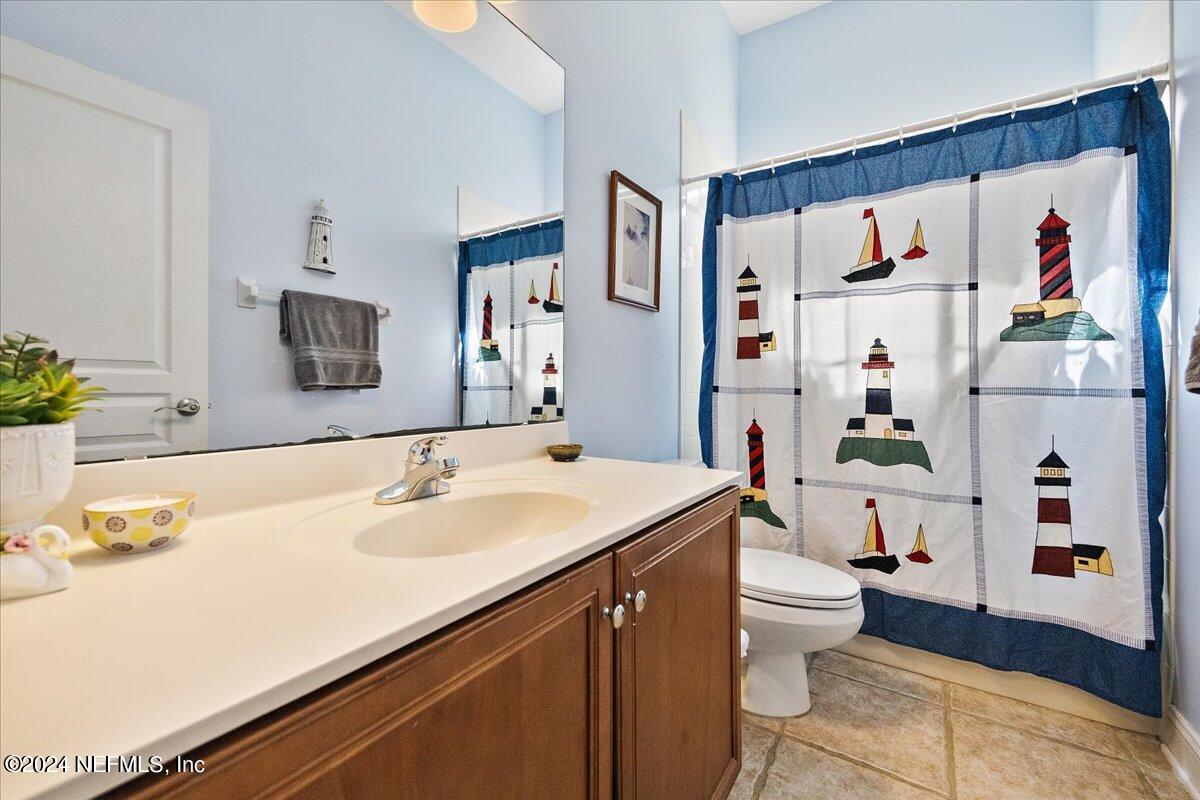 757 Eagle Point Drive St. Augustine, FL 32092 - Photo 21 of 44 a bathroom with a sink a toilet and a large mirror