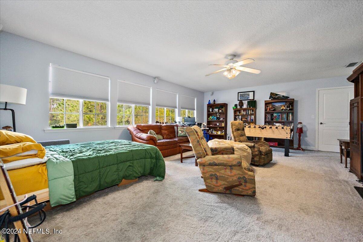 757 Eagle Point Drive St. Augustine, FL 32092 - Photo 23 of 44 a bedroom with a bed and a chandelier