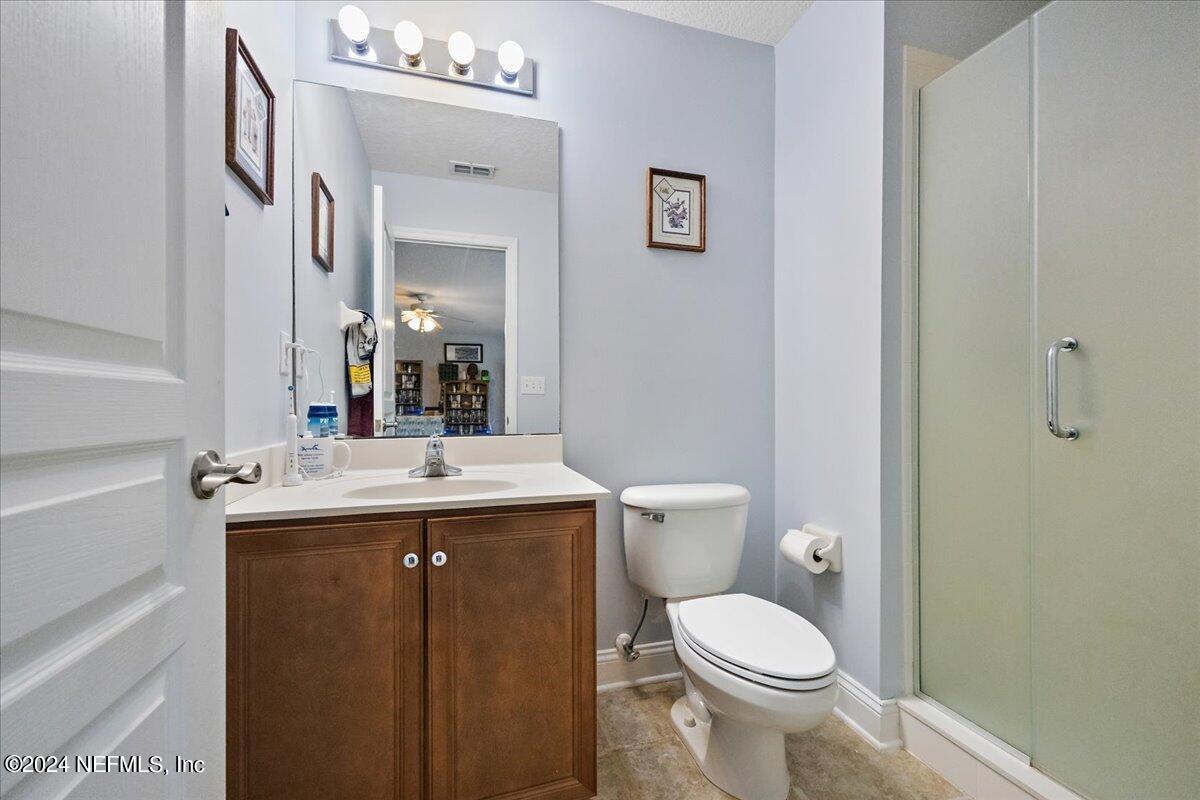757 Eagle Point Drive St. Augustine, FL 32092 - Photo 24 of 44 a bathroom with a granite countertop toilet sink and mirror