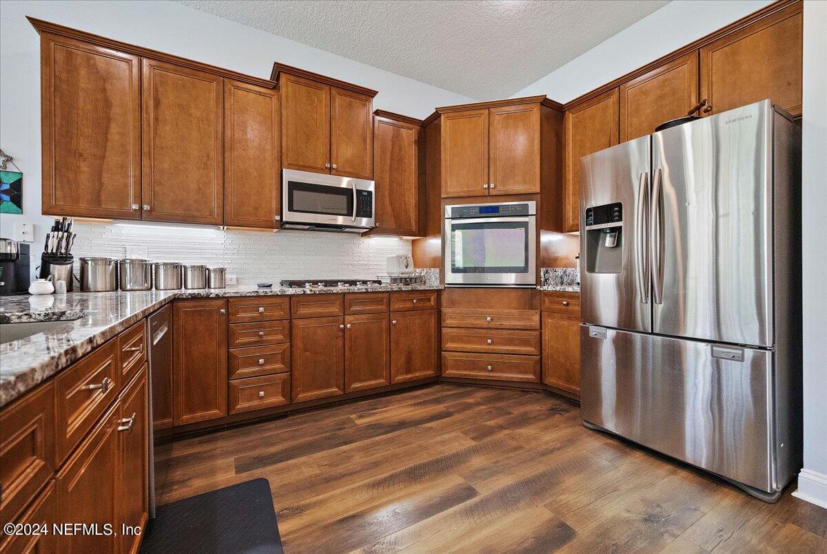 757 Eagle Point Drive St. Augustine, FL 32092 - Photo 9 of 44 a kitchen with stainless steel appliances granite countertop a refrigerator stove and sink