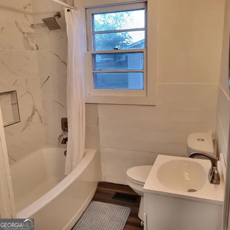 a bathroom with a sink and bathtub with toilet