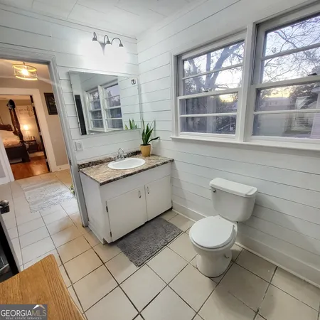 a bathroom with a sink toilet and window