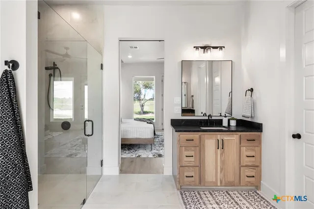 a bathroom with a granite countertop sink a mirror and a shower