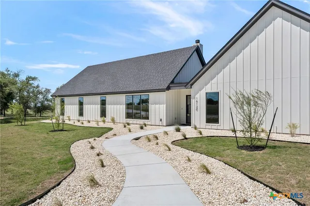 a view of a house with backyard sitting area and garden