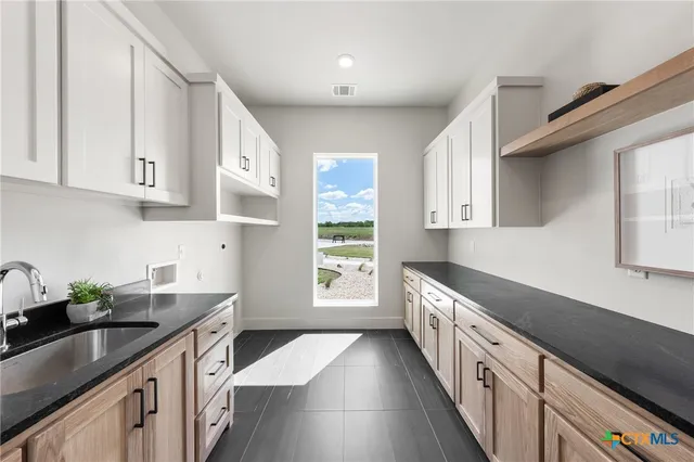 a kitchen with a sink stove and cabinets