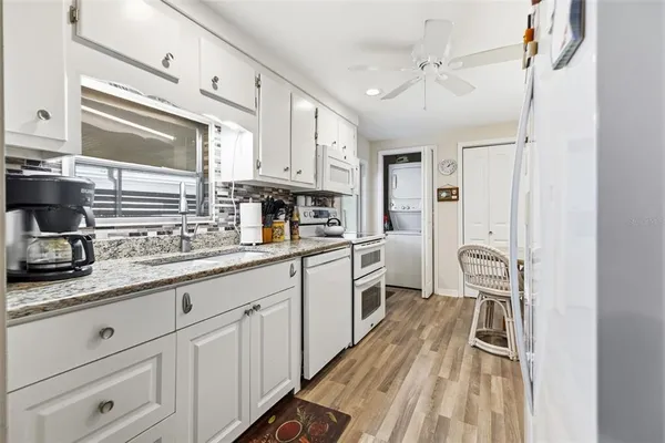 a kitchen with granite countertop cabinets a sink a window and stainless steel appliances