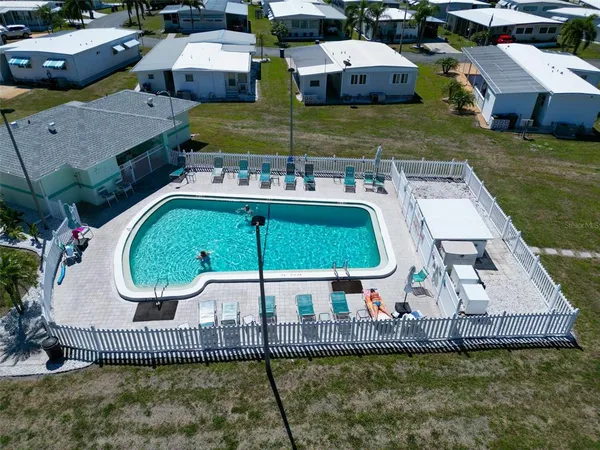 an aerial view of a house with swimming pool and a yard
