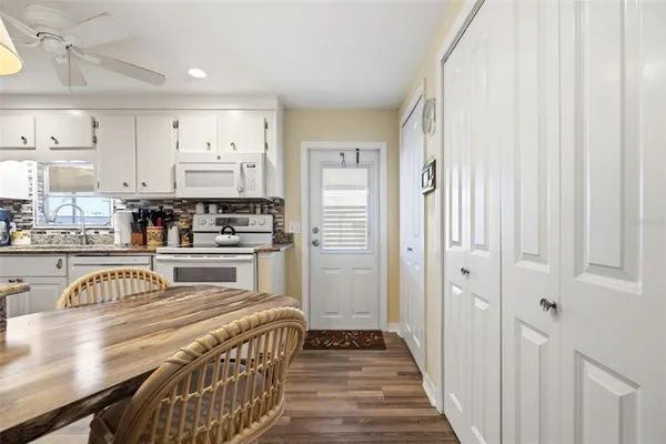a kitchen with stainless steel appliances a white stove top oven and a refrigerator with wooden floor