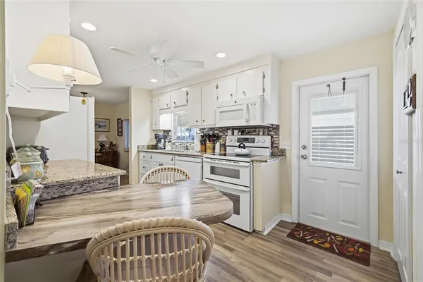 a kitchen with kitchen island granite countertop a refrigerator and a stove