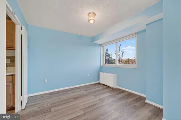 an empty room with wooden floor and window