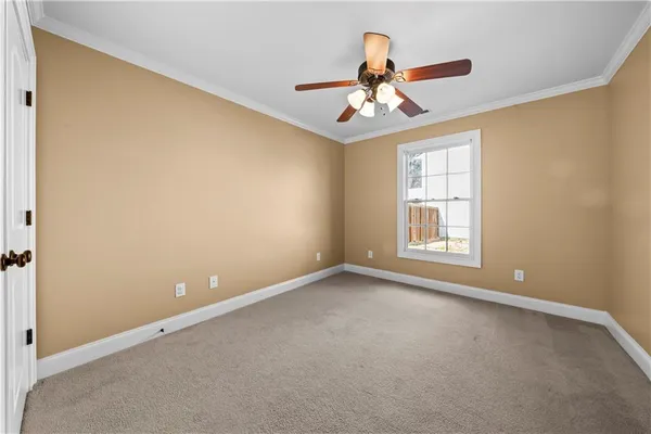 an empty room with chandelier fan