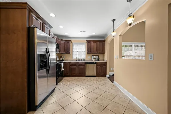 a kitchen with granite countertop stainless steel appliances a refrigerator sink microwave and cabinets