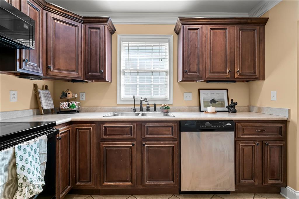 23 Walton Creek Drive Southwest Rome, GA 30165 - Photo 19 of 35 a kitchen with stainless steel appliances granite countertop wooden cabinets a sink and dishwasher a stove top oven with wooden floor