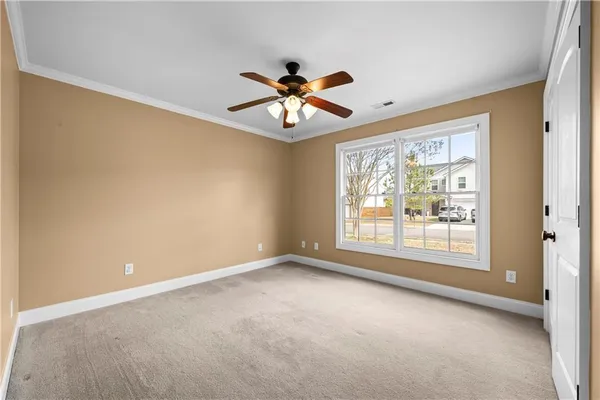 an empty room with chandelier fan