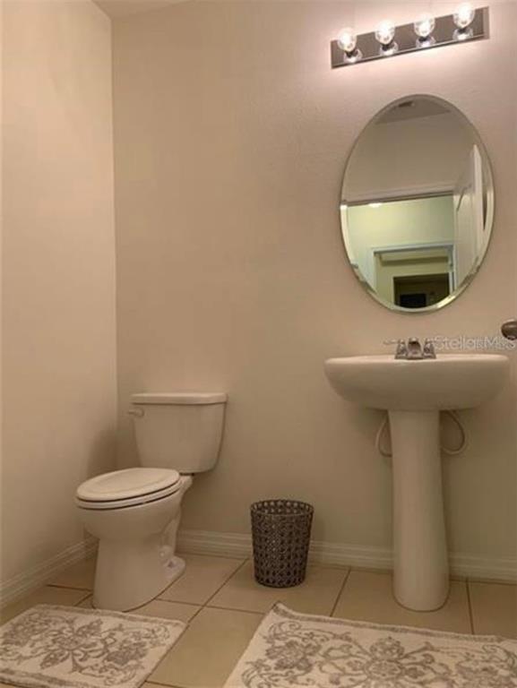 3740 Seneca Club Loop Orlando, FL 32808 - Photo 13 of 15 a bathroom with a toilet and a mirror