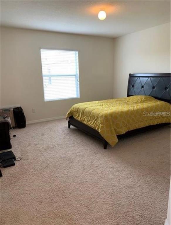 3740 Seneca Club Loop Orlando, FL 32808 - Photo 15 of 15 a bed sitting in a bedroom next to a window