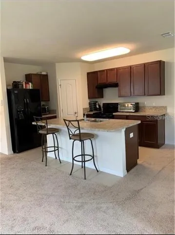 a kitchen with stainless steel appliances a stove a sink a microwave a refrigerator and cabinets