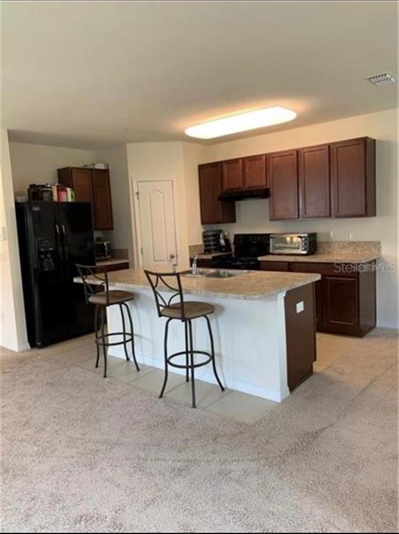 3740 Seneca Club Loop Orlando, FL 32808 - Photo 9 of 15 a kitchen with stainless steel appliances a stove a sink a microwave a refrigerator and cabinets